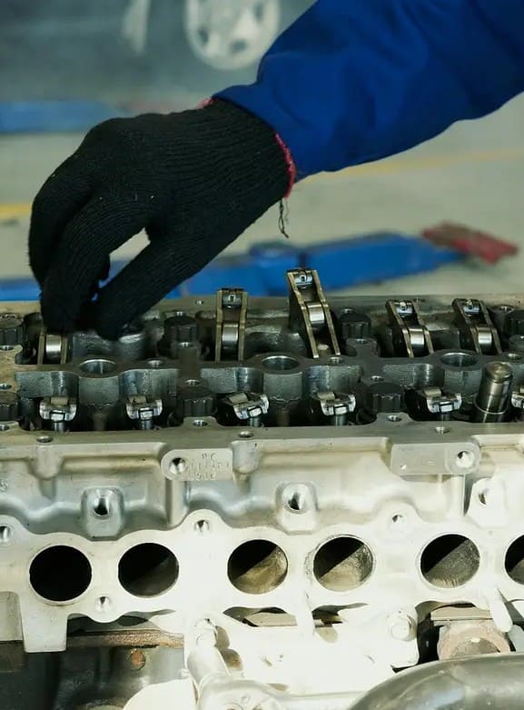 Doświadczony mechanik Celestynów wykonuje profesjonalną naprawę silnika w warsztacie samochodowym.